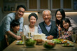 © imtmphoto - senior asian couple celebrating wedding annversary with three generational family