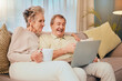 © C Haas/peopleimages.com - Sofa, laptop and senior couple in living room on comedy show, streaming social media video or meme for retirement lifestyle. Happy old woman drink coffee with her partner on couch and home technology