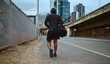© S Fanti/peopleimages.com - Fitness, black man and walking on city street after running, exercise and gym workout with a hoodie at night. Back of a male athlete in urban Miami for a walk and cardio training with a duffle bag