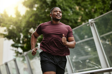 Wall Mural - Black man, fitness and running in park for healthy workout, exercise or cardio in the nature outdoors. Happy African American male runner enjoying a jog, run or exercising for health and wellness