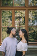 © Westend61 - Affectionate hipster man looking at girlfriend in front of window