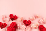 Fototapeta Mapy - Elegant Valentine day background with mix of sweet pink and red origami paper hearts flying on soft light pastel pink color, footer border, copy space, top view.