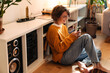 © Drobot Dean - Brunette young woman using cellphone while sitting on floor