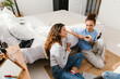 © Drobot Dean - Two young girls talking and drinking coffee while sitting on floor at home