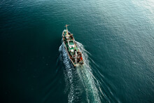 Fishing Boat Catching Fish Aerial Top View From Drone. Small Fishing Trawler Ship On Sea Surface.