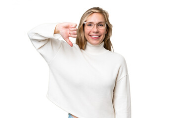 Wall Mural - Young blonde woman over isolated background showing thumb down with negative expression