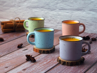 Golden milk with turmeric and cinnamon in mugs