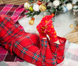 young woman in holiday pajamas laying down near christmas tree