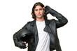 © luismolinero - Young handsome man with a motorcycle helmet isolated on green chroma background having doubts