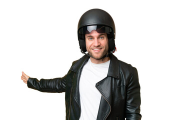 Canvas Print - Young caucasian man with a motorcycle helmet isolated on green chroma background extending hands to the side for inviting to come