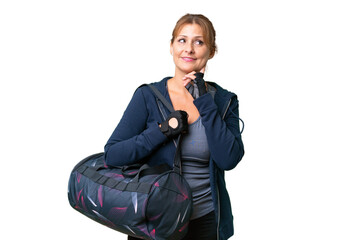 Wall Mural - Middle-aged sport woman with sport bag over isolated background thinking an idea while looking up