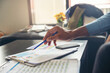 © prachid - Business and Financial Planning Concept. Professional Businessman hand discusses, point, and reviews annual report and graph. Financial advisor planning and working at home office.