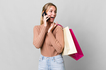 Wall Mural - pretty caucasian woman with shopping bags and a smartphone