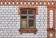 Old Wooden Window With A Red Frame In A White And Red Brick House.