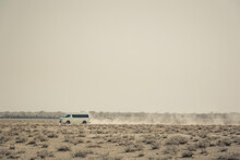 A Vehicle Driving On A Dusty Road, Etosha National Park; Namibia