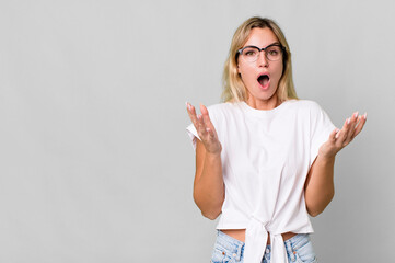 Wall Mural - caucasian blonde woman feeling extremely shocked and surprised. copy space concept