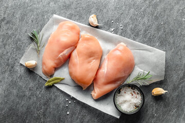 Poster - Raw chicken breast with spices on a dark background top view