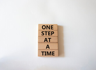 Wall Mural - One step at a time symbol. Concept words One step at a time on wooden blocks. Beautiful white background. Business and One step at a time concept. Copy space.