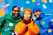 Multiracial group of young happy friends meeting outdoors in winter and celebrating party with colorful confetti, concepts about youth and event celebration