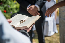 Two wedding rings rest on the Bible at a wedding