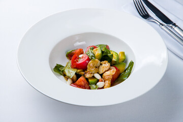 Sticker - salad with shrimp, avocado and tomatoes on a white plate