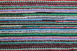 colored handmade rug made of natural threads on the floor selective focus, hobby