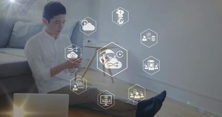 Poster - Animation of icons in hexagon over asian man sitting on ground with laptop and using cellphone