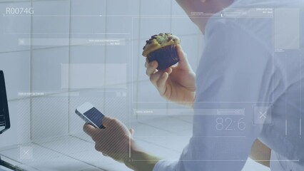 Poster - A person using a mobile phone while eating a muffin in a kitchen at home