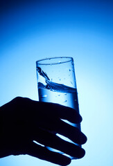 closeup of pouring water on the cup on transparent blue background