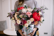 Very Nice Young Woman Holding Big And Beautiful Floral Composition Of Fresh Tender Peony, Roses, Eustoma, Gypsophila, Statice Flowers In White, Purple And Red Colors, Bouquet Close Up