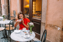Woman Eating Croissant In Rome Italy