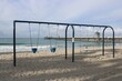© Chiara Sakuwa - Swing set on beach near pier