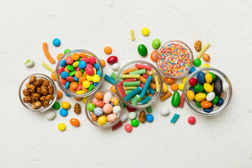 Poster - different colored round candy in bowl and jars. Top view of large variety sweets and candies with copy space