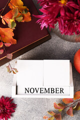 Sticker - Thanksgiving day, holiday celebrated every fourth Thursday in November. Flat lay composition with wooden block calendar and autumn leaves on grey table