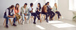 © Studio Romantic - People developing and practicing conversation skills in foreign language at English speaking club. Diverse group of serious adult students talking to each other sitting on row of chairs in classroom