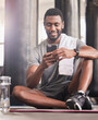 © Lune V A/peopleimages.com - Fitness, phone and black man relax and smile for online communication, sports workout or watching exercise tutorial in gym. Happiness, training wellness video on mobile and rest after cardio run