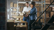 © Gorodenkoff - European Male and African Female Working in a Warehouse. Talking, Using Laptop Computer, Checking Retail Stock, Preparing Shipment. Rows of Shelves Full of Cardboard Box Parcels in the Background.
