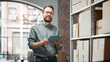 © Gorodenkoff - Portrait of a Successful Employee Checking Inventory, Writing in Tablet Computer. Stylish Man Posing for Camera and Smiling in a Warehouse Storeroom with Orders Ready for Shipment.