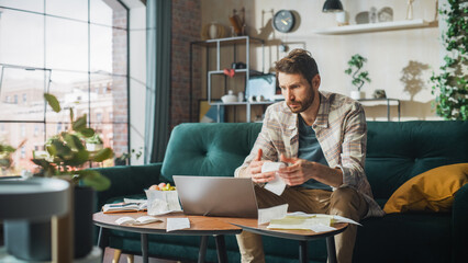 Accounting at Home: Streessed Man Using Laptop Computer, Filling Tax Forms. Businessman Scared of Bankruptcy. Paperwork Problems: Bills, Invoices, Budget Deficit, High Inflacion, Financial Difficulty