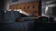 © Gorodenkoff - Man Wakes Up, Turns off Alarm Clock with Frustration, after Sleepless Insomniac Night. Early Rising Stressed Man Ready to Face Day of Problem Solving. Focus on the Clock Showing Six A.M.