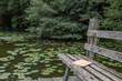 © ADDICTIVE STOCK - Copybook placed on old wooden bench near pond