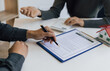 © Wasan - Legally signing a real estate contract agreement, Real estate agents calculate and quote a house for sale with a calculator.