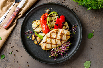 Wall Mural - Grilled chicken Breasts with grilled vegetables on black plate top view