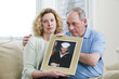 © Designpics - Portrait of a mature couple holding picture of their son working in the military