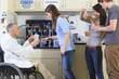 © Designpics - Professor with a spinal cord injury in a wheelchair talking to engineering students about laboratory glassware