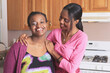 © Designpics - Two sisters smiling in the kitchen one with a learning disability