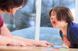 © Designpics - Little girl with Down Syndrome playing a learning game with her Mom