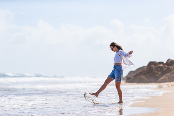 Wall Mural - Young happy woman on the beach enjoy her summer vacation. Girl is happy and calm in her stay on the beach