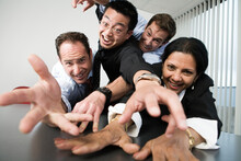 View Of Businesspeople Grabbing On To A Desk.