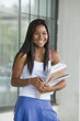 © Designpics - Teenage girl holding books and smiling in a school